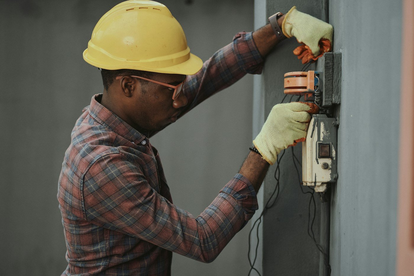 Technicien en casque de chantier intervenant sur une installation électrique